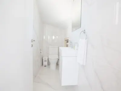 a white bathroom with a toilet and a sink at Holiday Home Protaras Villa mit Pool am Strand der Fig Tree Bay by Interhome in Protaras