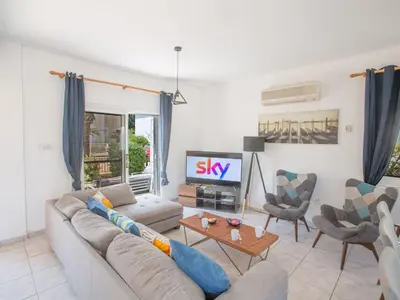 a living room with a couch and a tv at Holiday Home Protaras Villa mit Pool am Strand der Fig Tree Bay by Interhome in Protaras