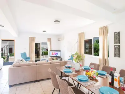 a living room with a couch and a table and chairs at Holiday Home in Protaras mit privatem Parkplatz by Interhome in Protaras