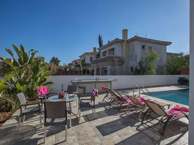 a patio with chairs and a table next to a pool at Holiday Home Protaras Perle Villa PE15 by Interhome in Protaras