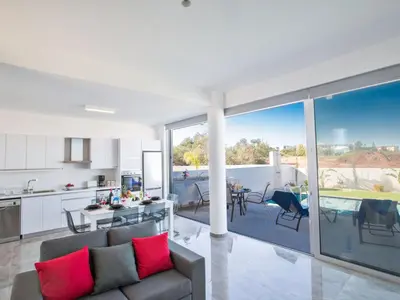 a kitchen and living room with red pillows on a couch at Holiday Home Protaras Olivine Villa mit Pool und einem Dachgarten by Interhome in Protaras