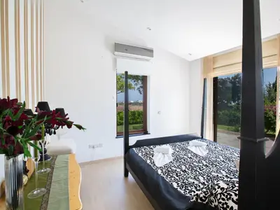 a bedroom with a black and white bed and a table at Holiday Home 4-Schlafzimmer-Villa mit Pool im Zentrum von Protaras by Interhome in Protaras