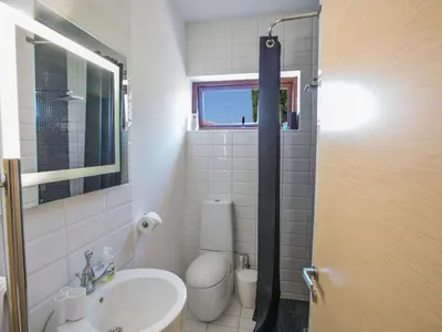 a bathroom with a sink and a toilet and a window at Holiday Home 4-Schlafzimmer-Villa mit Pool im Zentrum von Protaras by Interhome in Protaras