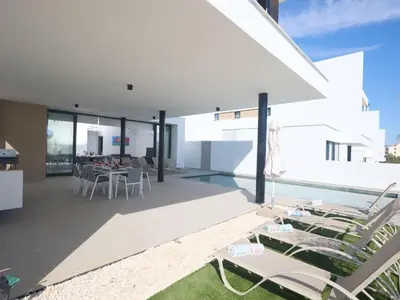 a patio with a table and chairs and a pool at Holiday Home Protaras Aqua Pearl Villa AQ12 by Interhome in Protaras