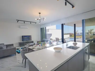 a kitchen and living room with a white counter top at Holiday Home Protaras Aqua Pearl Villa AQ12 by Interhome in Protaras