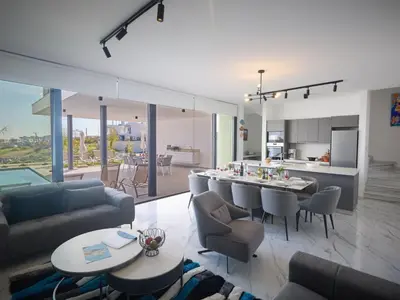 a living room with a couch and a table with chairs at Holiday Home Protaras Aqua Pearl Villa AQ12 by Interhome in Protaras