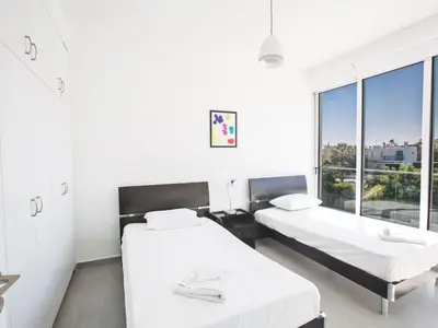 two beds in a room with a window at Holiday Home Wunderschöne- geräumige Ferienvilla mit BBQ by Interhome in Protaras