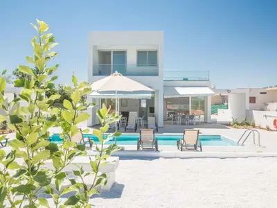 a villa with a swimming pool and an umbrella at Holiday Home Wunderschöne- geräumige Ferienvilla mit BBQ by Interhome in Protaras