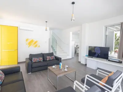 a living room with a couch and a table at Holiday Home Greco Villa CCV4- 5-Schlafzimmer-Villa mit privatem Pool in Protaras Zentrum by Interhome in Protaras