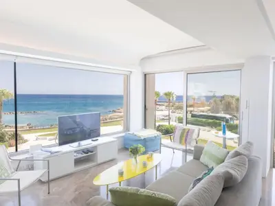 a living room with a tv and a large window at Apartment Luxuriöse Wohnung am Strand von Thalassa by Interhome in Protaras