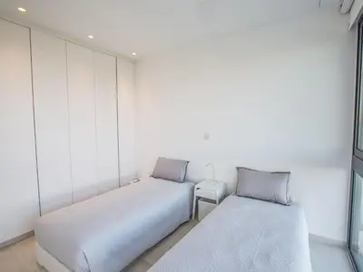 two beds in a room with white walls at Holiday Home Neue- moderne 3-Schlafzimmer-Villa mit privatem Pool by Interhome in Paralimni