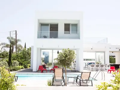 a white house with a pool and chairs at Holiday Home Protaras Greco Villa CCV1 mit beheiztem Pool by Interhome in Protaras