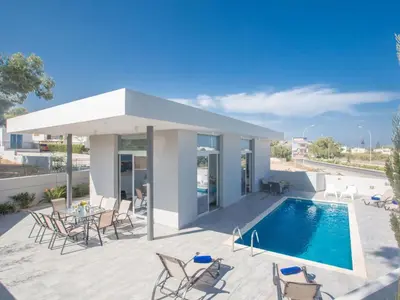 a patio with a pool and chairs and a house at Holiday Home Protaras - schönes Ferienhaus für 10 Personen by Interhome in Protaras