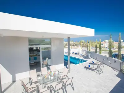 a patio with a table and chairs and a pool at Holiday Home Protaras - schönes Ferienhaus für 10 Personen by Interhome in Protaras