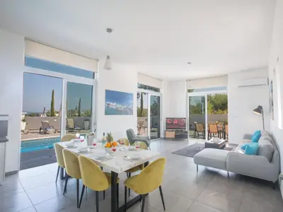a dining room and living room with a table and chairs at Holiday Home Protaras - schönes Ferienhaus für 10 Personen by Interhome in Protaras
