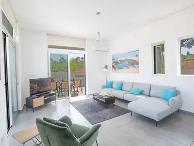 a living room with a couch and chairs and a tv at Holiday Home Protaras - schönes Ferienhaus für 10 Personen by Interhome in Protaras