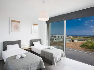 two beds in a room with a large window at Holiday Home Ferienvilla Olivine Pearl mit Meerblick by Interhome in Protaras