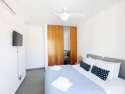 a bedroom with a white bed and a television at Holiday Home Ayia Napa Satin Villa SVI1 by Interhome in Ayia Napa