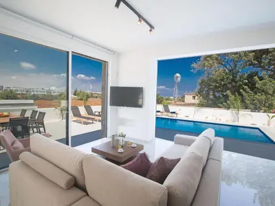 a living room with a couch and a swimming pool at Holiday Home 4-Schlafzimmer-Villa mit Pool im Zentrum von Protaras by Interhome in Protaras