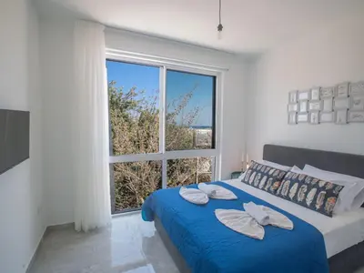 a bedroom with a blue bed with a large window at Holiday Home 4-Schlafzimmer-Villa mit Pool im Zentrum von Protaras by Interhome in Protaras