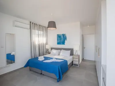 a bedroom with a bed with a blue blanket at Holiday Home Schöne Villa Olivine Pearl OL5 mit Garten by Interhome in Protaras