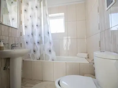 a white bathroom with a toilet and a shower curtain at Holiday Home Charmante 3-Schlafzimmer-Villa DI12 mit privatem Pool by Interhome in Protaras