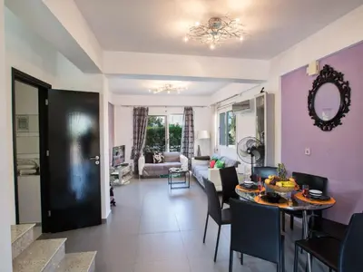a living room with purple walls and a table and chairs at Holiday Home Charmante 3-Schlafzimmer-Villa DI12 mit privatem Pool by Interhome in Protaras
