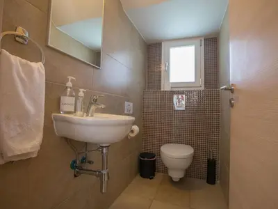 a bathroom with a sink and a toilet at Holiday Home 3-Schlafzimmer-Luxusvilla mit Pool und teilweise Meerblick by Interhome in Protaras