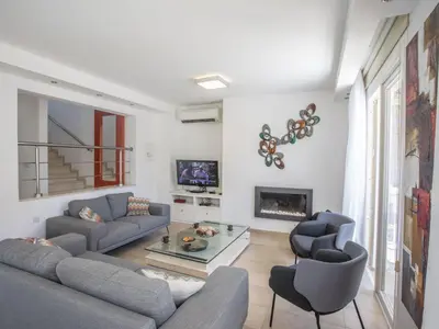 a living room with a couch and chairs and a fireplace at Holiday Home 3-Schlafzimmer-Luxusvilla mit Pool und teilweise Meerblick by Interhome in Protaras