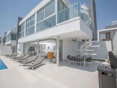 an exterior view of a house with chairs and tables at Holiday Home Haus in Pernera mit Bi-Fold Patio by Interhome in Protaras