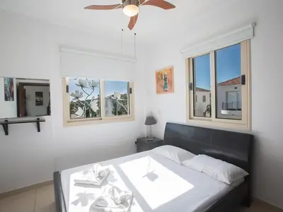 a bedroom with a bed with a ceiling fan and windows at Holiday Home Ferienvilla PV17 mit Sonnenterrasse und Pool by Interhome in Protaras