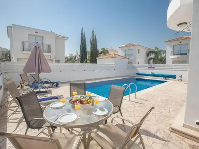 a patio with a table and chairs and a pool at Holiday Home Ferienvilla PV17 mit Sonnenterrasse und Pool by Interhome in Protaras