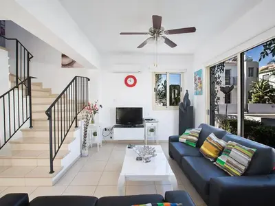a living room with a blue couch and a tv at Holiday Home Ferienvilla PV17 mit Sonnenterrasse und Pool by Interhome in Protaras