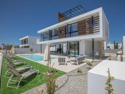 a villa with a swimming pool and lounge chairs at Holiday Home in Protaras mit großem Garten by Interhome in Protaras