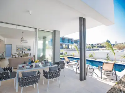 a patio with a table and chairs and a pool at Holiday Home 3-Schlafzimmer-Villa mit privatem Pool im Zentrum by Interhome in Protaras