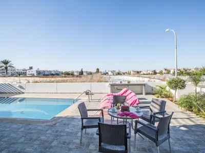 a patio with a table and chairs next to a pool at Holiday Home Protaras Perle Villa PE16 by Interhome in Protaras