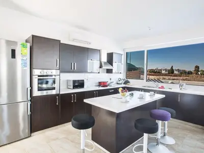 a kitchen with stainless steel appliances and purple stools at Holiday Home Protaras Perle Villa PE16 by Interhome in Protaras