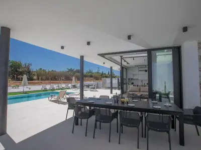 a dining area with a table and chairs and a pool at Holiday Home mit Privatpool für 11 Personen ca- 220 m² in Protaras- Südküste von Zypern by Interhome in Protaras