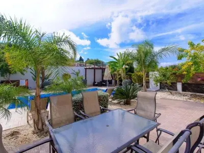 a patio with a table and chairs and a pool at Holiday Home Protaras Ferienvilla AV6 by Interhome in Protaras