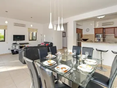 a dining room and living room with a glass table and chairs at Holiday Home Protaras Ferienvilla AV6 by Interhome in Protaras