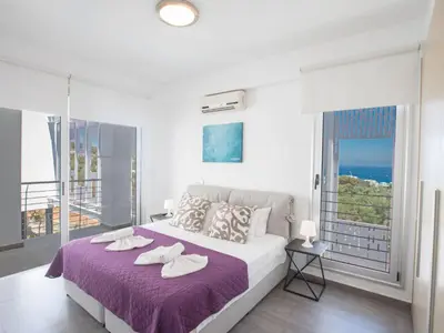 a bedroom with a bed with purple sheets and a balcony at Holiday Home Ferienvilla Chloe mit Terrasse und Garten by Interhome in Protaras