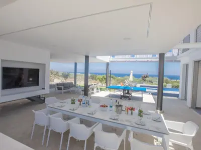 a dining room with a table and white chairs at Holiday Home Ferienvilla Chloe mit Terrasse und Garten by Interhome in Protaras