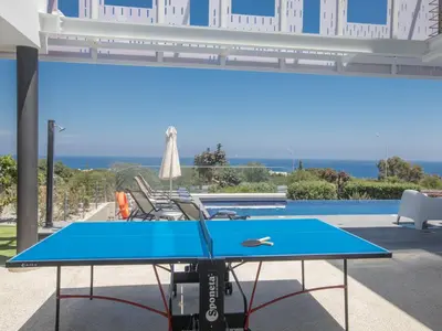 a blue ping pong table in front of a pool at Holiday Home Ferienvilla Chloe mit Terrasse und Garten by Interhome in Protaras