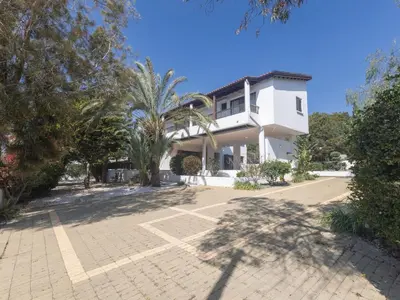 a white house with a palm tree and a driveway at Holiday Home Ferienvilla Mo 3 für 10 Personen in Agia Napa by Interhome in Ayia Napa
