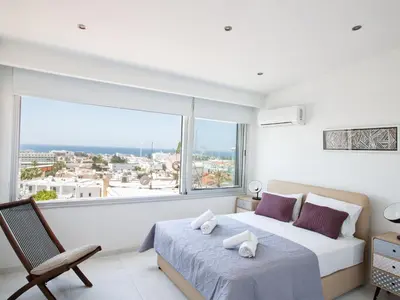 a white bedroom with a bed and a large window at Apartment Schöne Wohnung in Ayia Napa mit Garten by Interhome in Ayia Napa