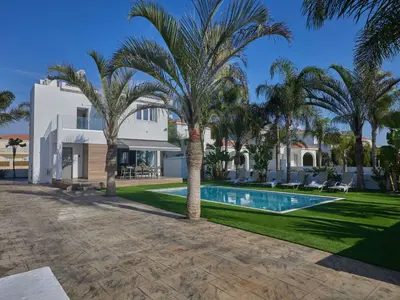 a villa with a swimming pool and palm trees at Holiday Home Moderne- geräumige Ferienvilla by Interhome in Ayia Napa