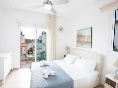 a white bedroom with a bed and a balcony at Holiday Home 3-Schlafzimmer-Villa mit privatem Pool by Interhome in Protaras