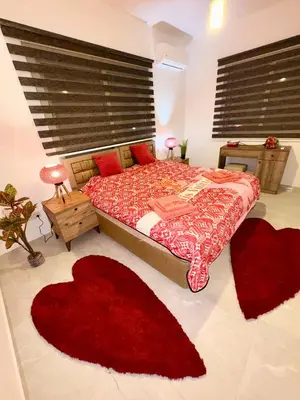 a bedroom with a bed with two red rugs at Lapta Red 1 bedroom apartment