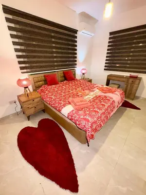 a bedroom with a large bed with a red blanket at Lapta Red 1 bedroom apartment