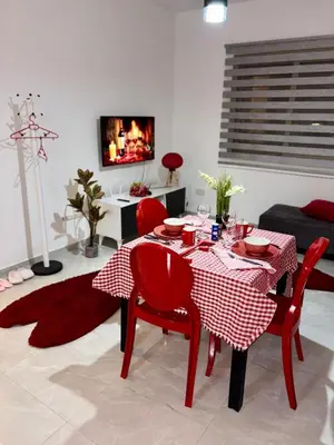 a red table and chairs in a living room at Lapta Red 1 bedroom apartment